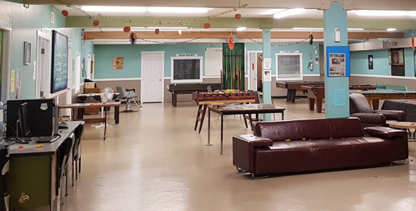 Open community drop-in space with couches, tables, and activity areas.