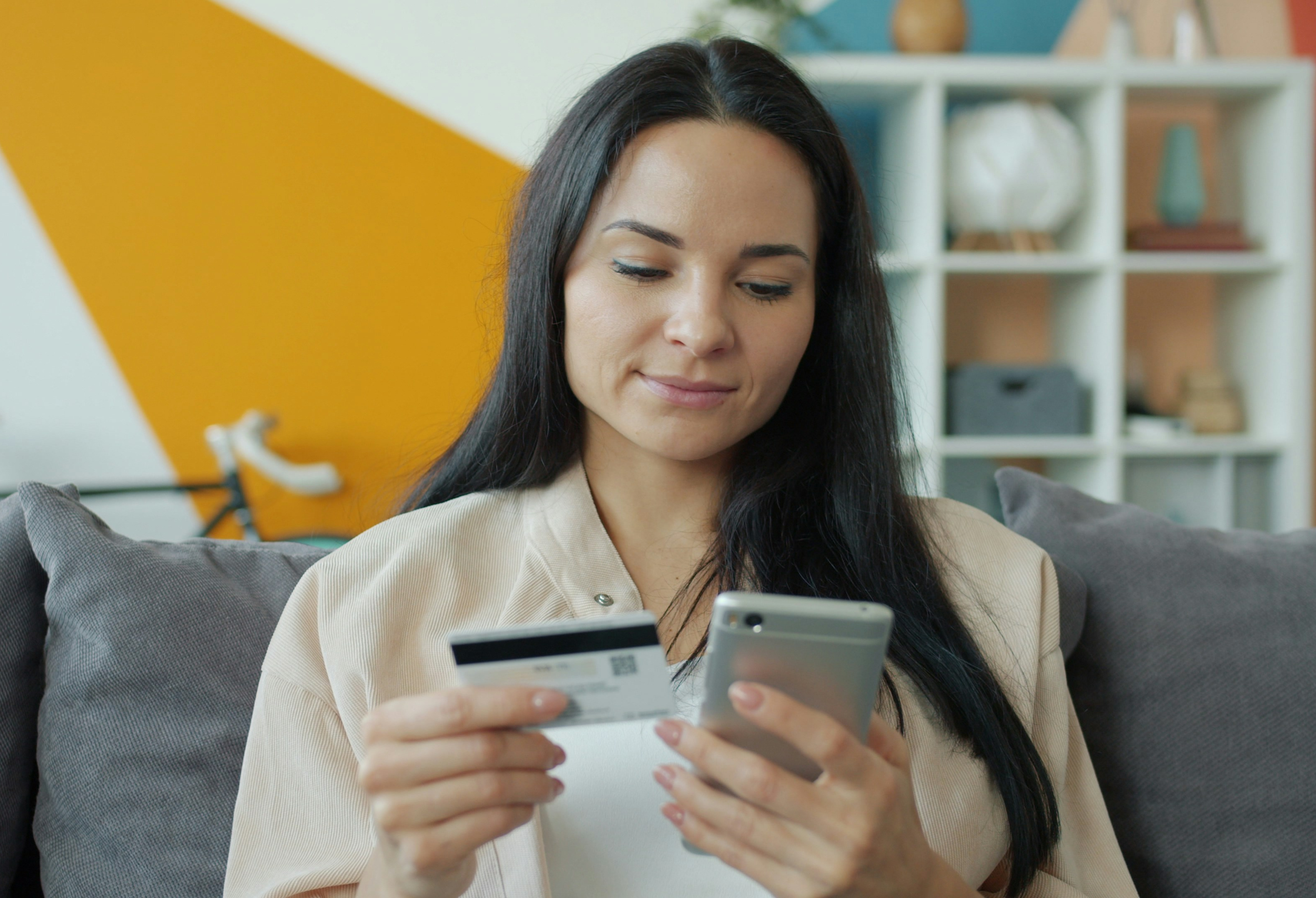 Person using a smartphone and credit card to make an online donation.